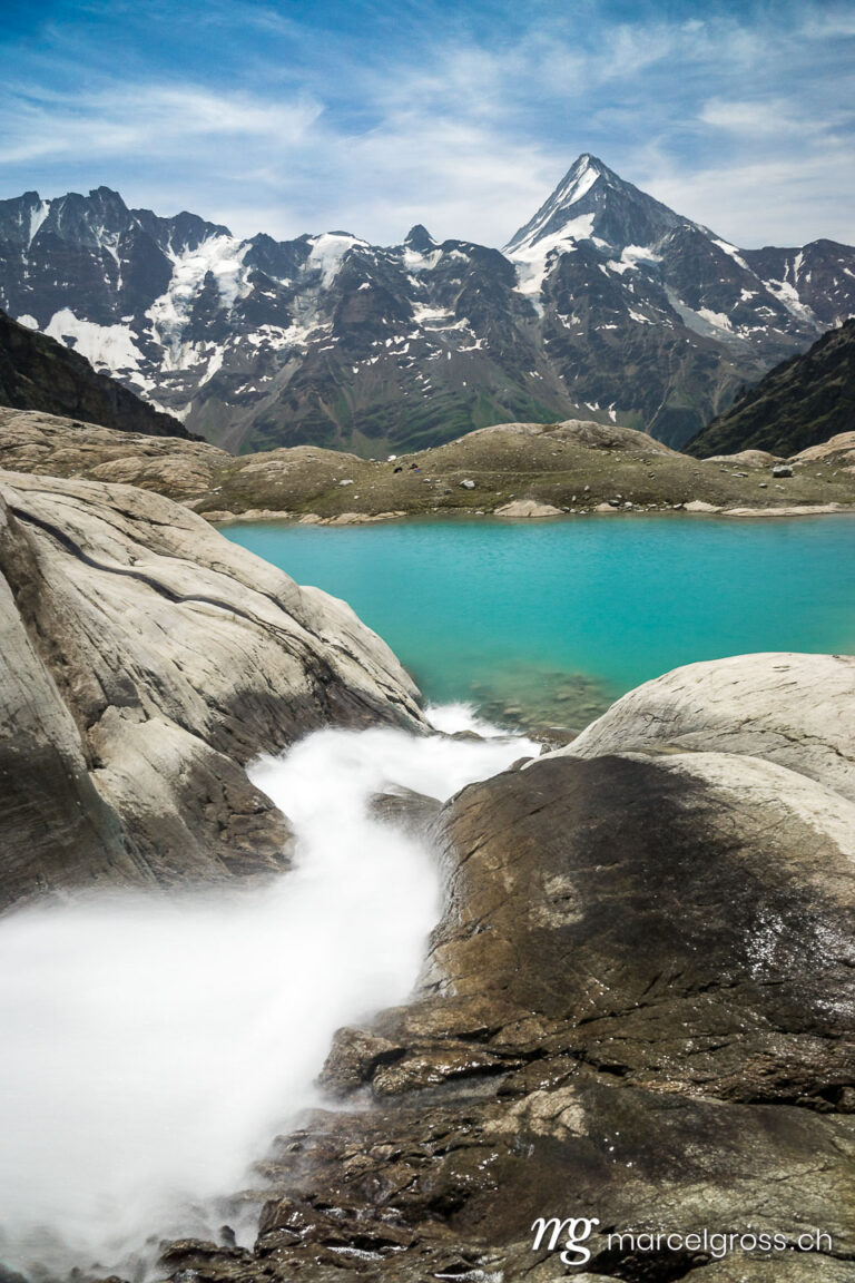 glacial creek with a turquoise lake and Mount Bietschhorn in the Swiss Alps. Captured while hiking with a friend in Lötschental, Valais.. Taken by Marcel Gross Photography