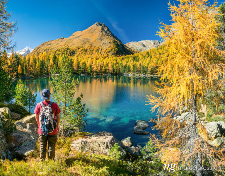 Autumn picture Switzerland. Hikers at Lago di Saoseo in autumn, Puschlav, Switzerland. Marcel Gross Photography