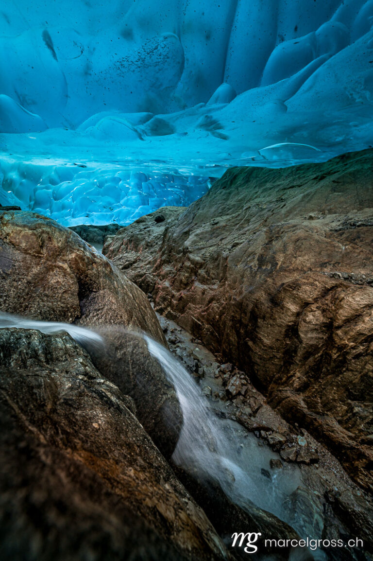 . waterfall below the Aletsch Glacier in an ice cave. Marcel Gross Photography