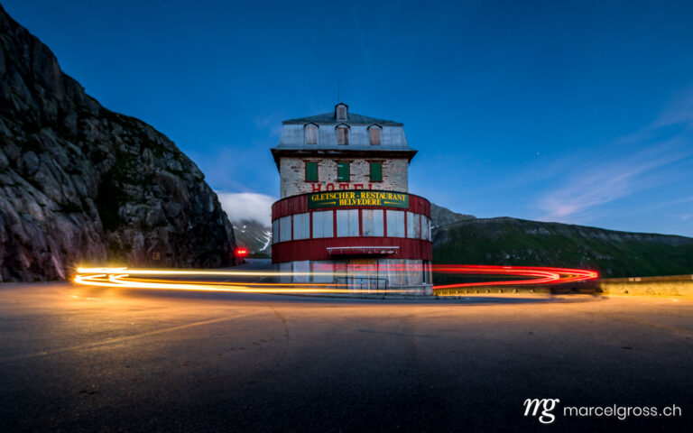 . long exposure of passing car at a hotel on a swiss alpine pass street. Marcel Gross Photography