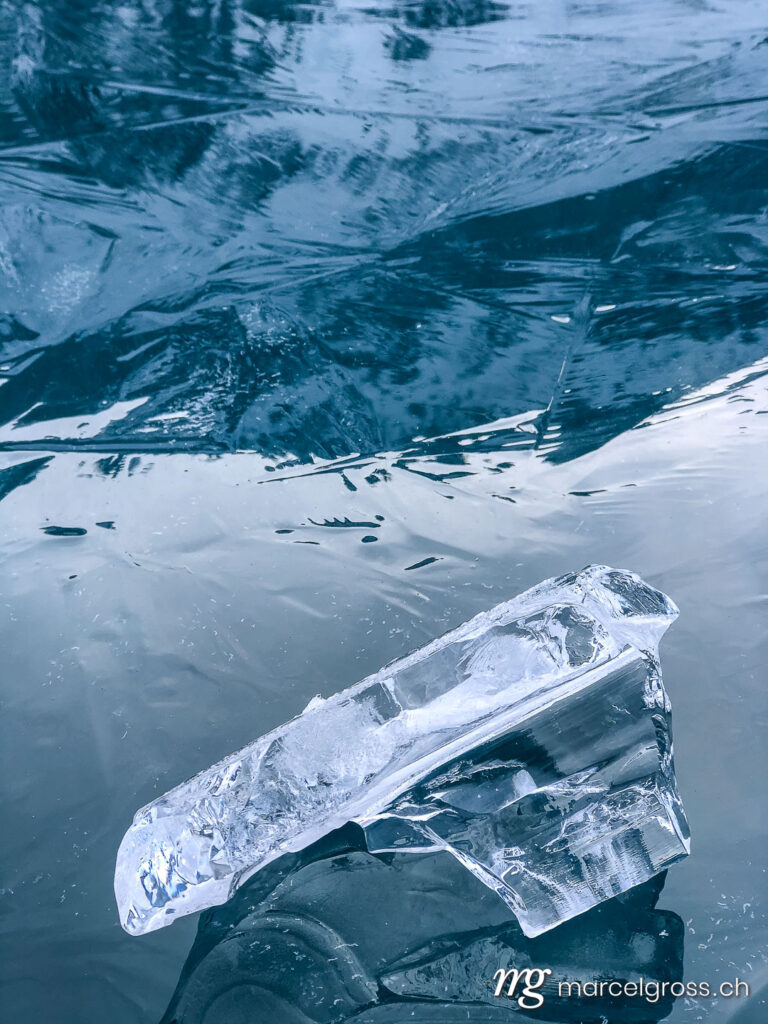 Winterbild Schweiz. beautiful icicle on black ice of frozen lake Oeschinensee in the Bernese Alps. Marcel Gross Photography