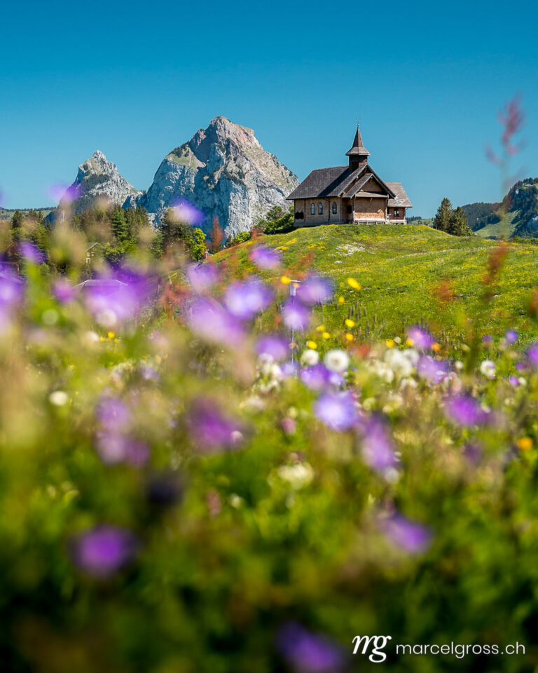 Summer picture Switzerland. Stoos mountain chapel in front of the Mythen in alpine summer. Marcel Gross Photography