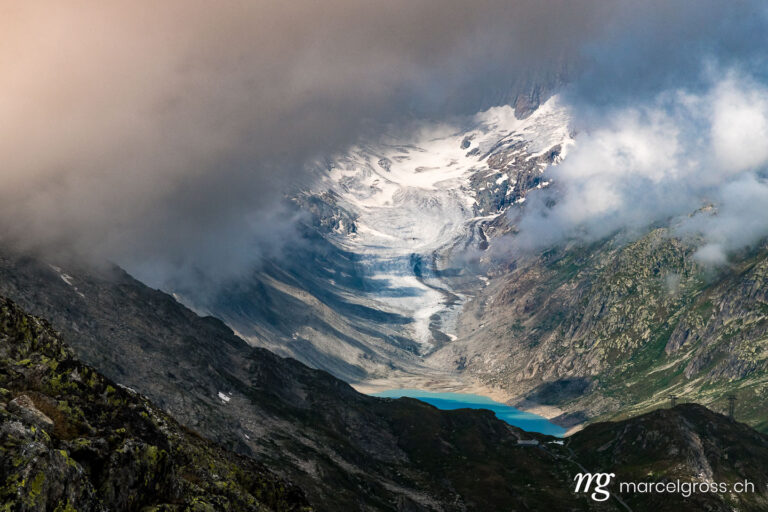 . Blick durch die Wolken auf den Oberaargletscher und Oberaarsee. Marcel Gross Photography