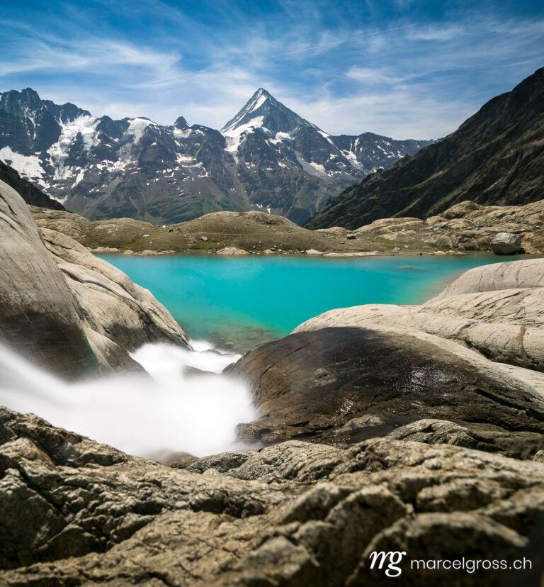 . Mountain Stream above emerald blue Blauseeli. Marcel Gross Photography