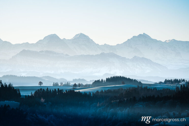 Winterbild Schweiz. Eiger Mönch and Jungfrau and the hills of Emmental on a winter morning. Marcel Gross Photography