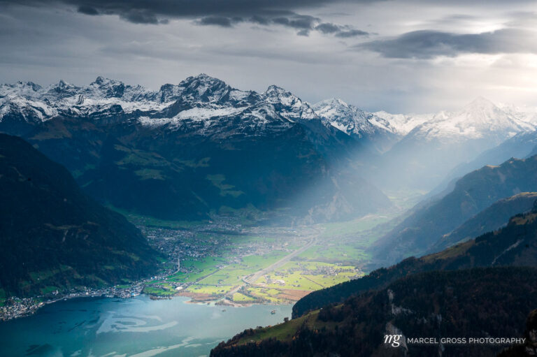 sun rays shining into Reussebene with Altdorf, Schattdorf, Gross Windgällen and Urnersee. Taken by Marcel Gross Photography