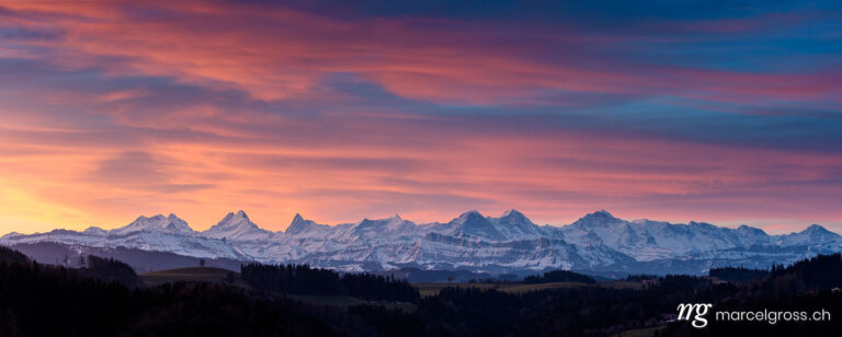 . colorful winter sunrise in Emmental with the Bernese Alps in the distance. Marcel Gross Photography