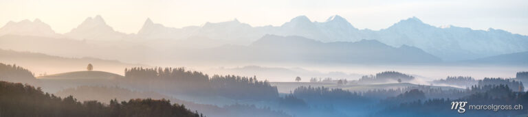 Panorama pictures Switzerland. Panoramic view over the sea of autumn fog and the hills of Emmental with the mighty bernese alsp in the background. Marcel Gross Photography