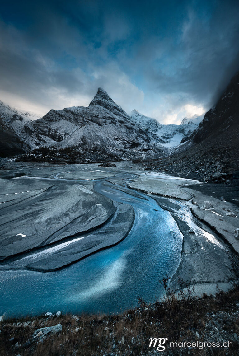 . wild meandering glacial river in Ferpecle, with impressive peak of Mont Miné in Valais. Marcel Gross Photography