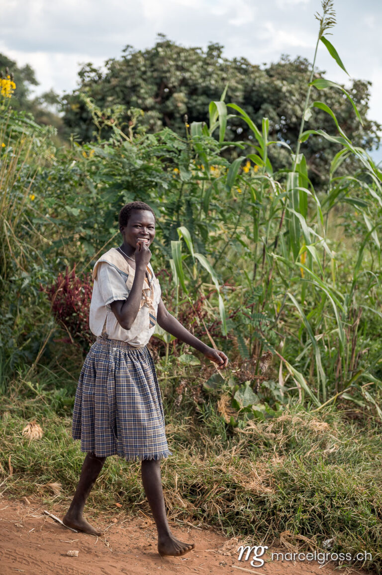 Uganda pictures. a karamojong woman walking from the field in the remote Karamoja Region of Uganda. Marcel Gross Photography