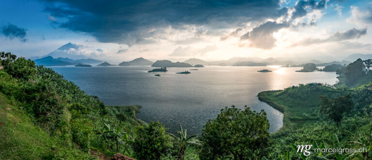 Uganda pictures. Panoramic landscape of Mount Muhabura and Lake Mutanda with it's islands in the late afternoon. Marcel Gross Photography