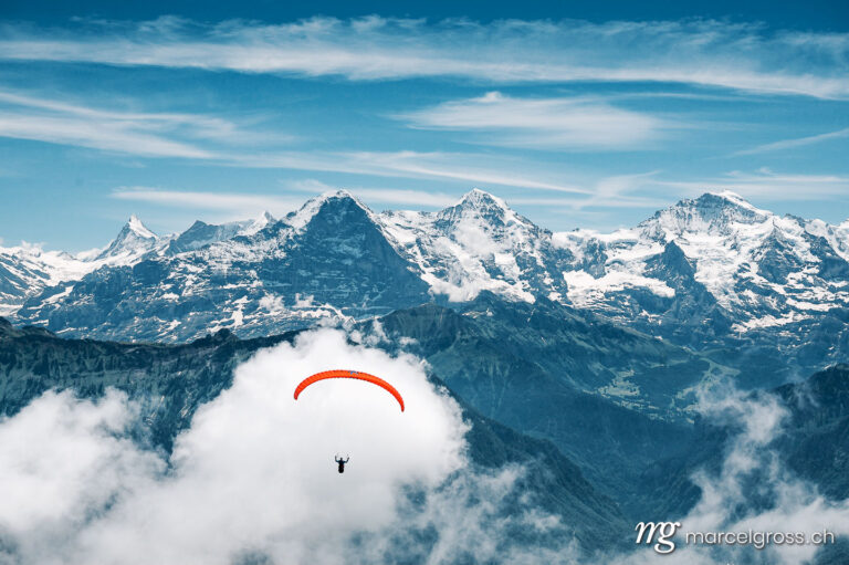 Sommerbilder Schweiz. paragliding flyer in the Bernese Alps in front of Eiger Mönch and Jungfrau. Marcel Gross Photography