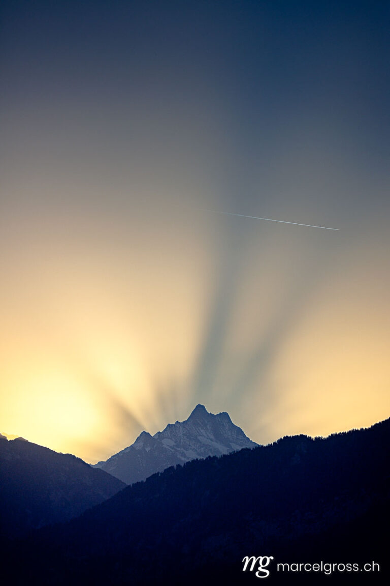 . autumn sunrise behind Schreckhorn in the Bernese alps creating halo effect. Marcel Gross Photography