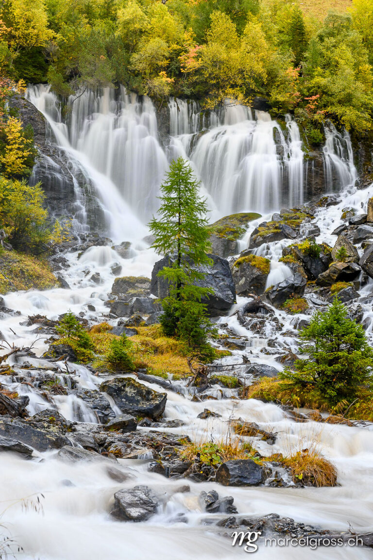 autumn waterfall. Sibe Brünne Waterfalls in Lenk in autumn foliage. Marcel Gross Photography